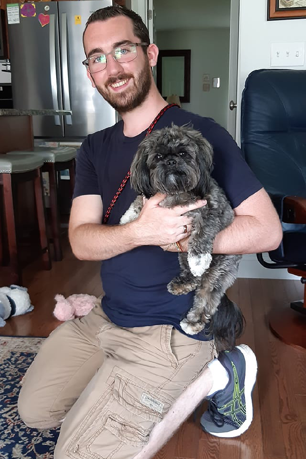 Dog training session with Alex holding a small dog in a New Hampshire home