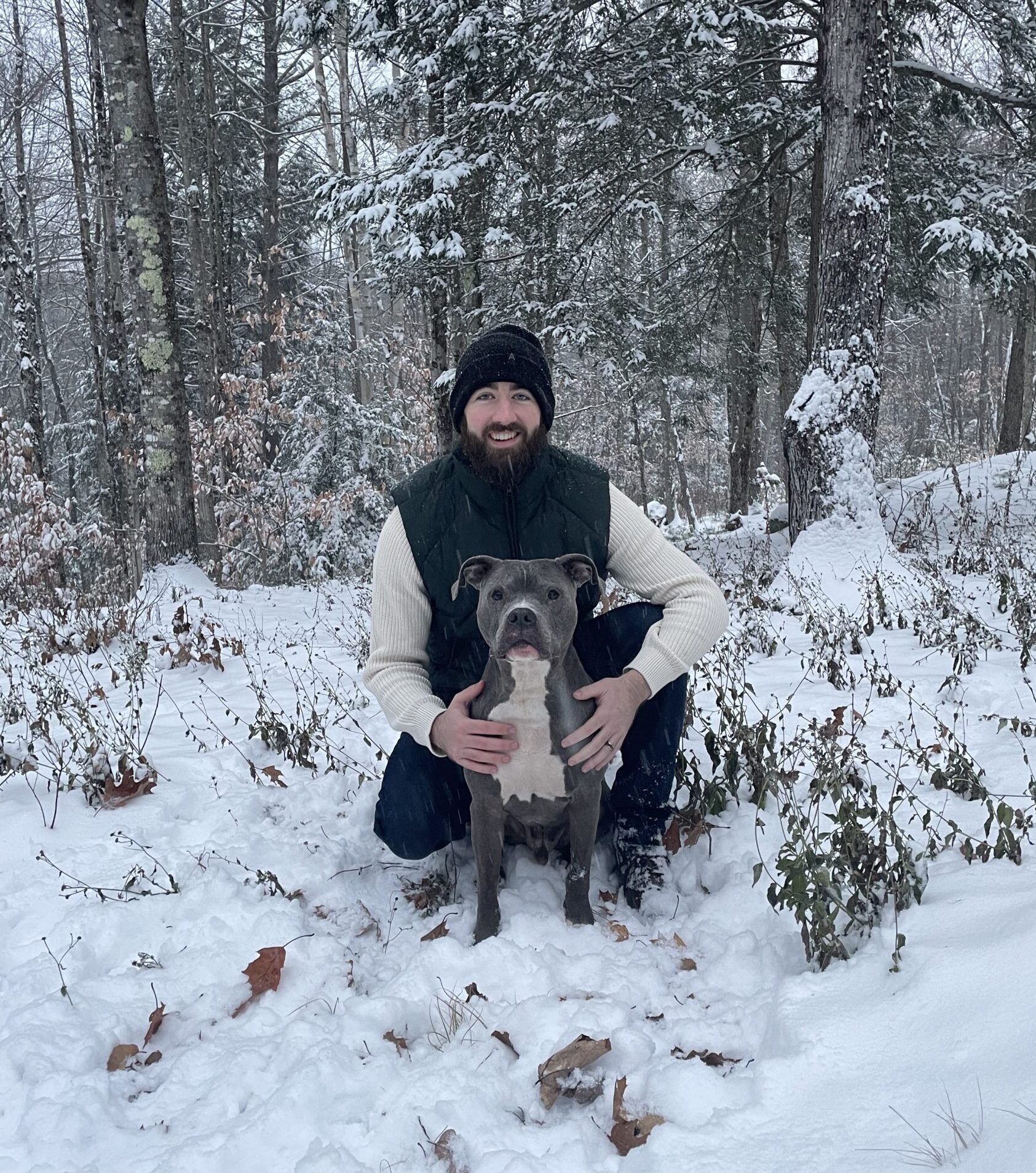 Head trainer Alex with his dog, sitting together in the snow
