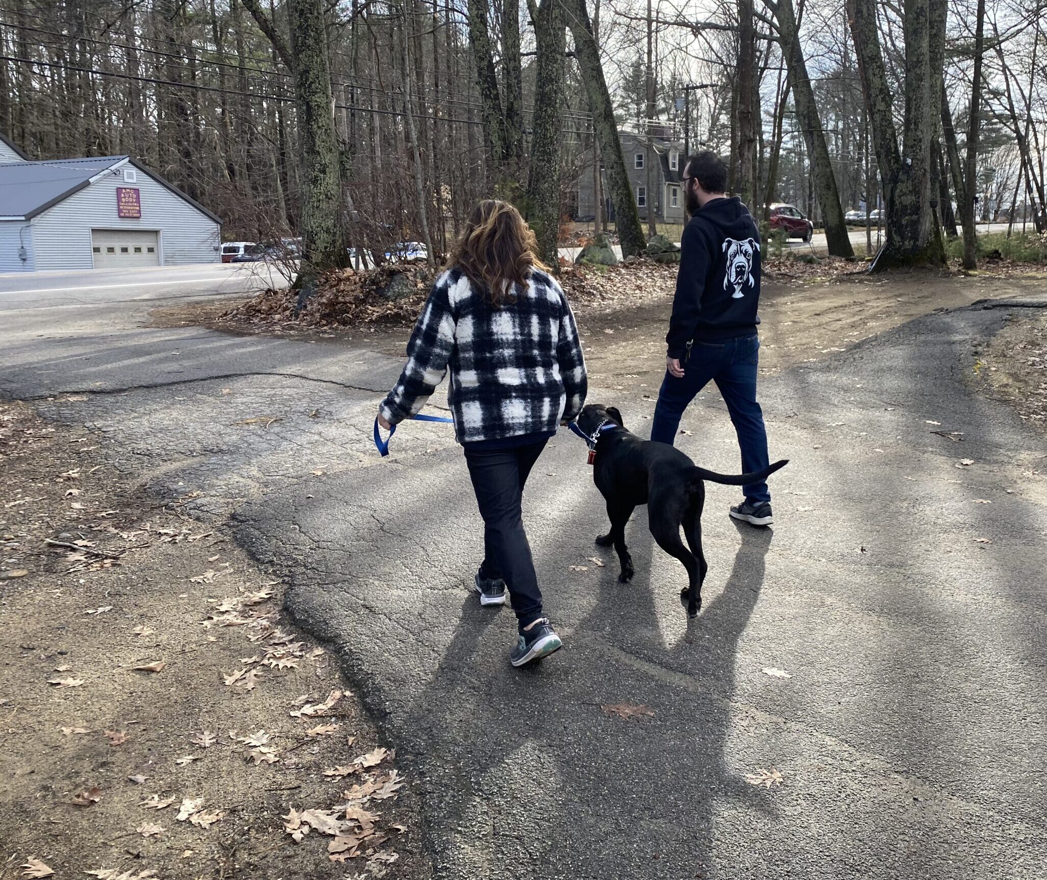 Trainer and client walking with dog in a relaxed heel walk